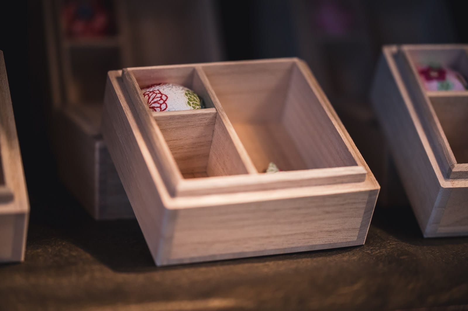 A wooden box with a pin cushion inside