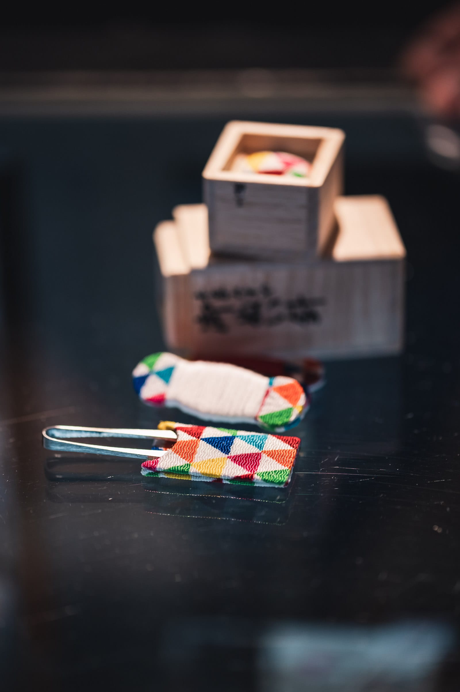 Scissors packaged in fabric, with thread and a storage box lying in the background out of focus