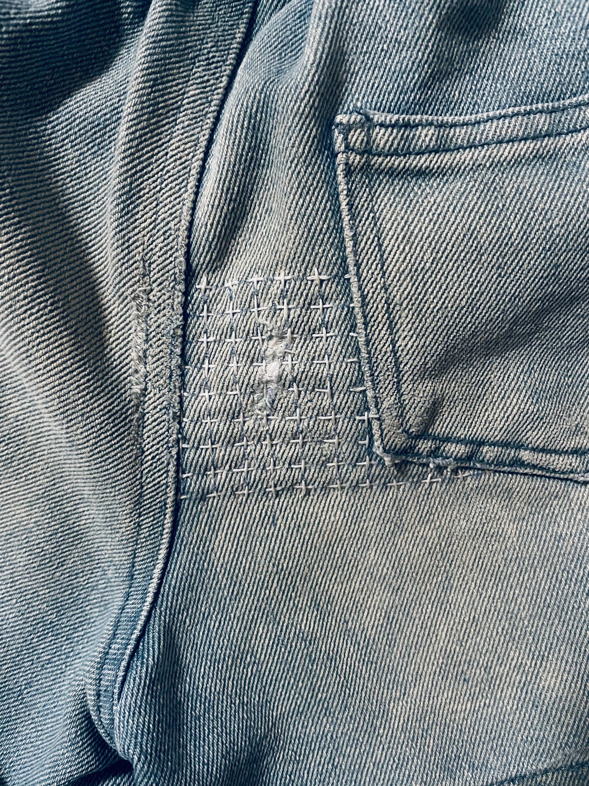 Light blue denims are patched with sashiko done in white thread