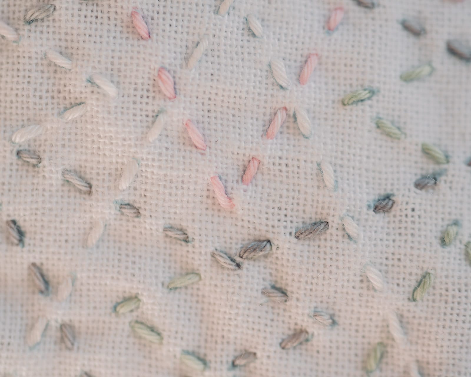 The sashiko pattern tsuzukiyamagata in pastel colors on white fabric up close