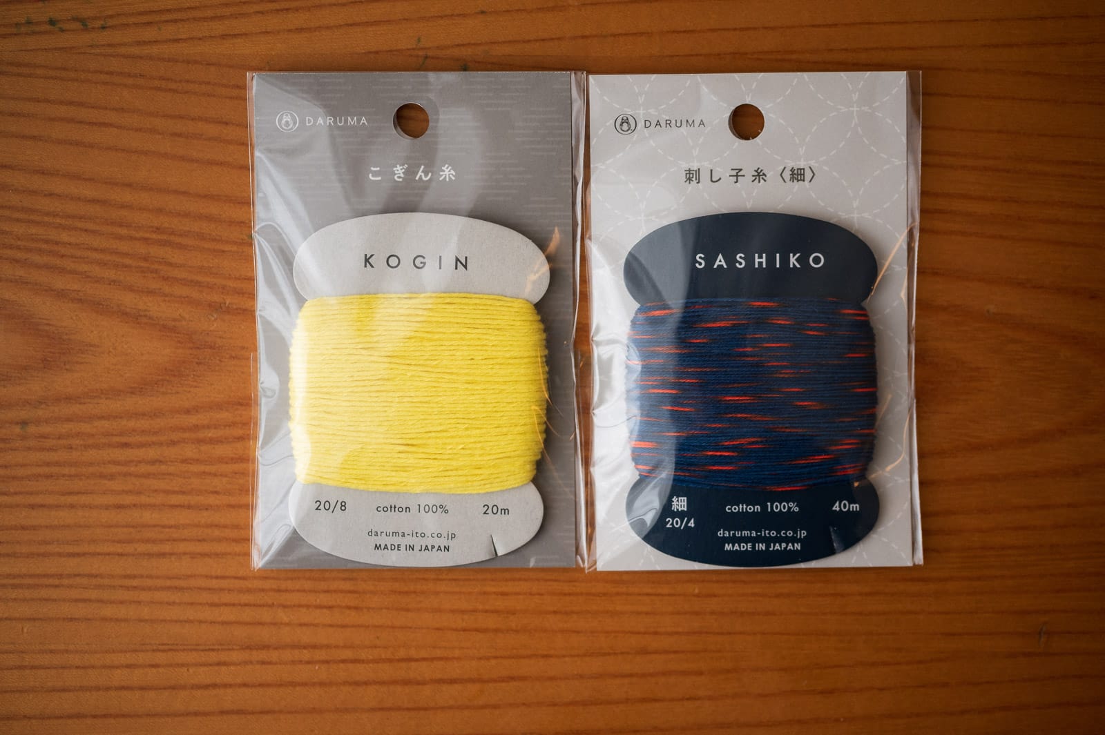 Kogin thread and sashiko thread in packages lying next to each other on a table.