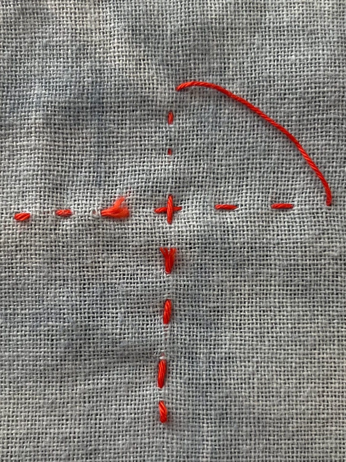 White fabric with red sashiko stitches close up