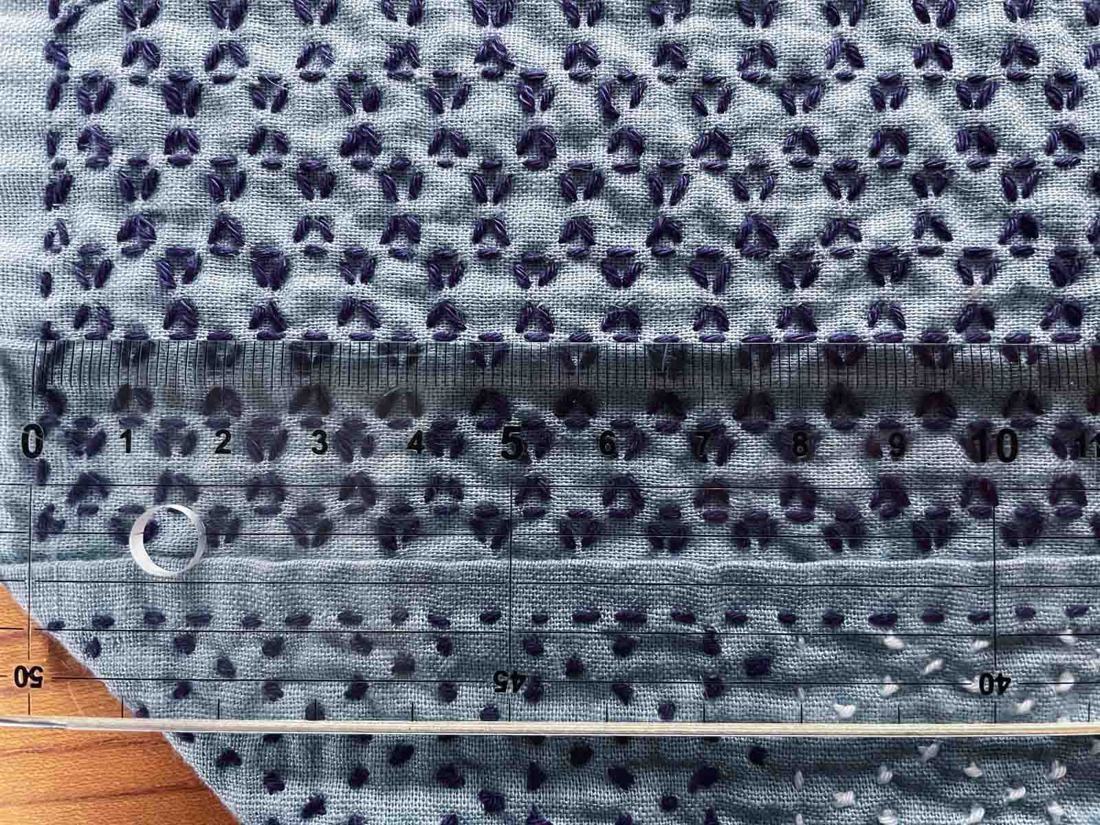 Sashiko cloth with ruler laid on top of kagome pattern to measure stitch length.