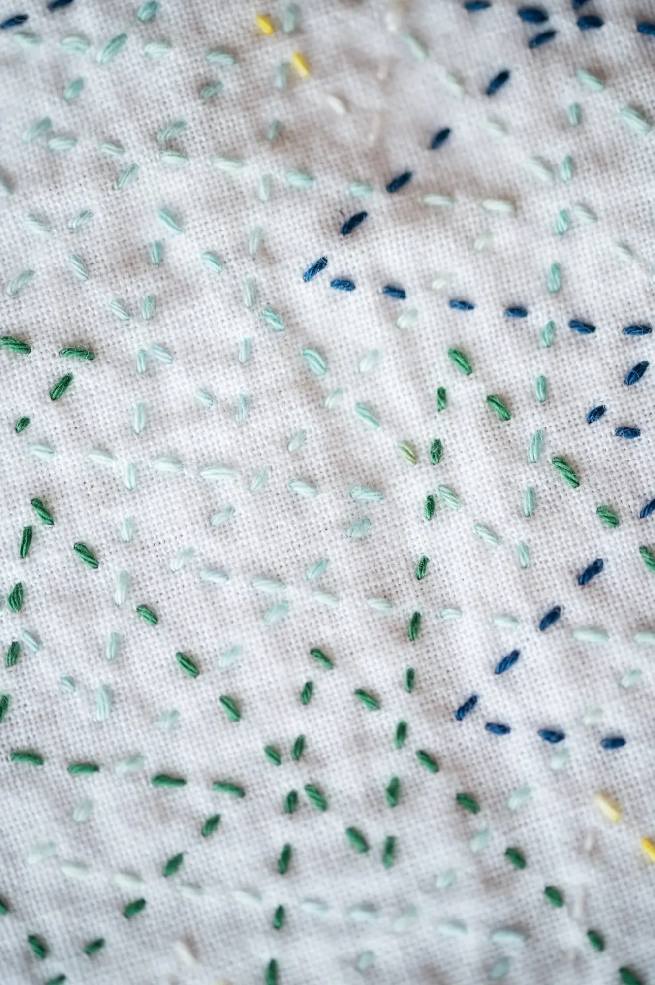 The sashiko pattern tsuzukiyamagata in vibrant colors on white fabric up close