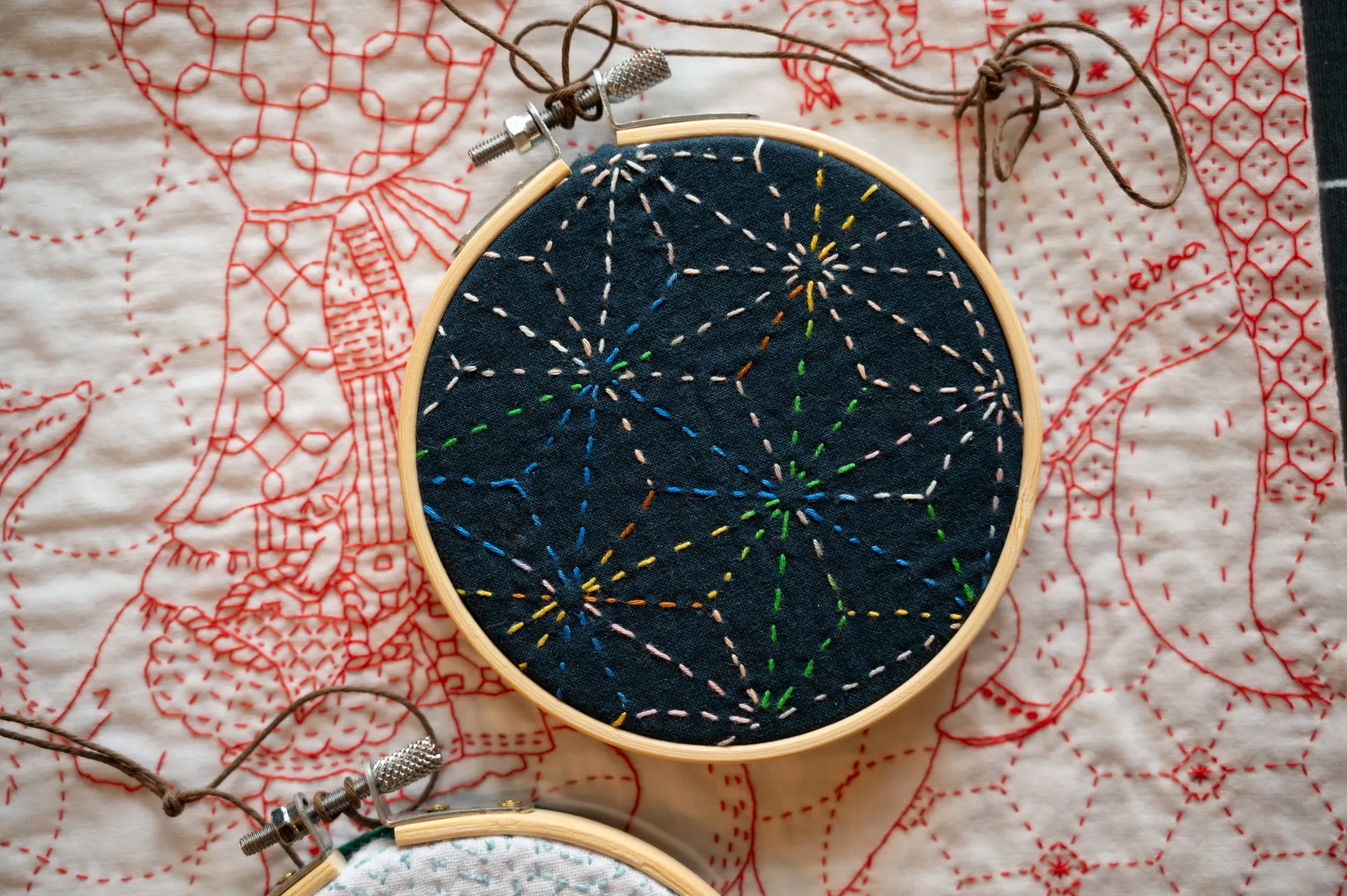 The asanoha sashiko pattern in variegated thread framed in an embroidery hoop