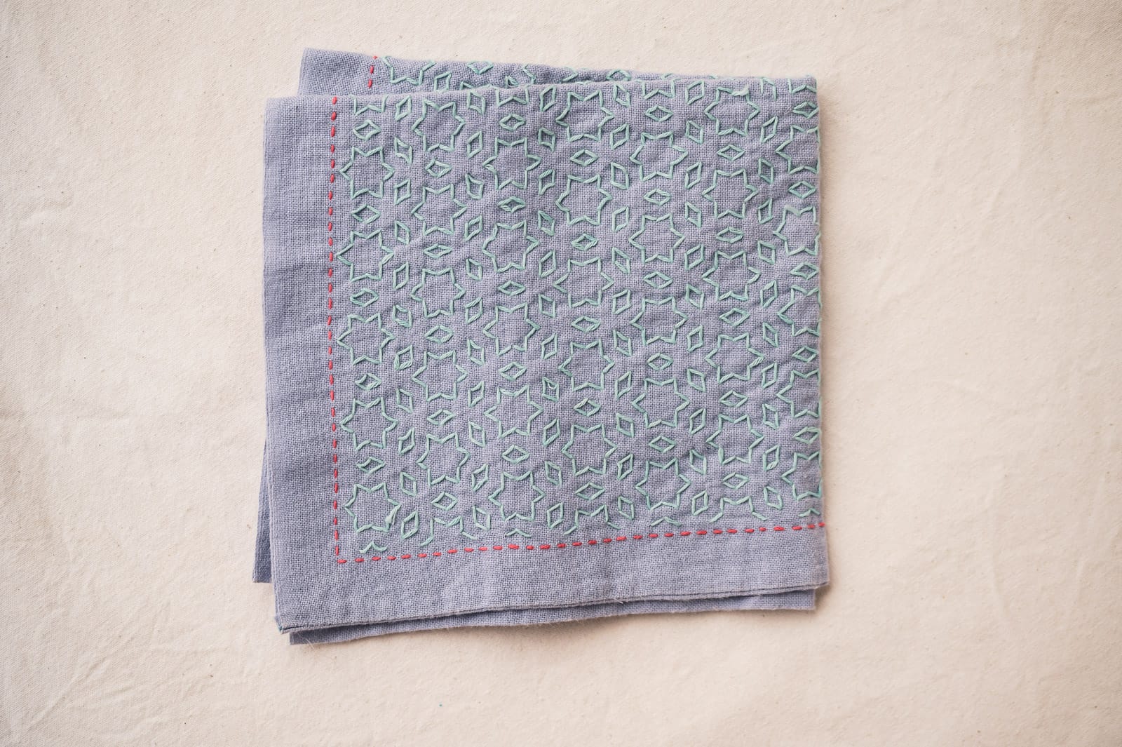 Sashiko pattern hoshi to mitsubishi 星と三菱 on mauve fabric in pale green.