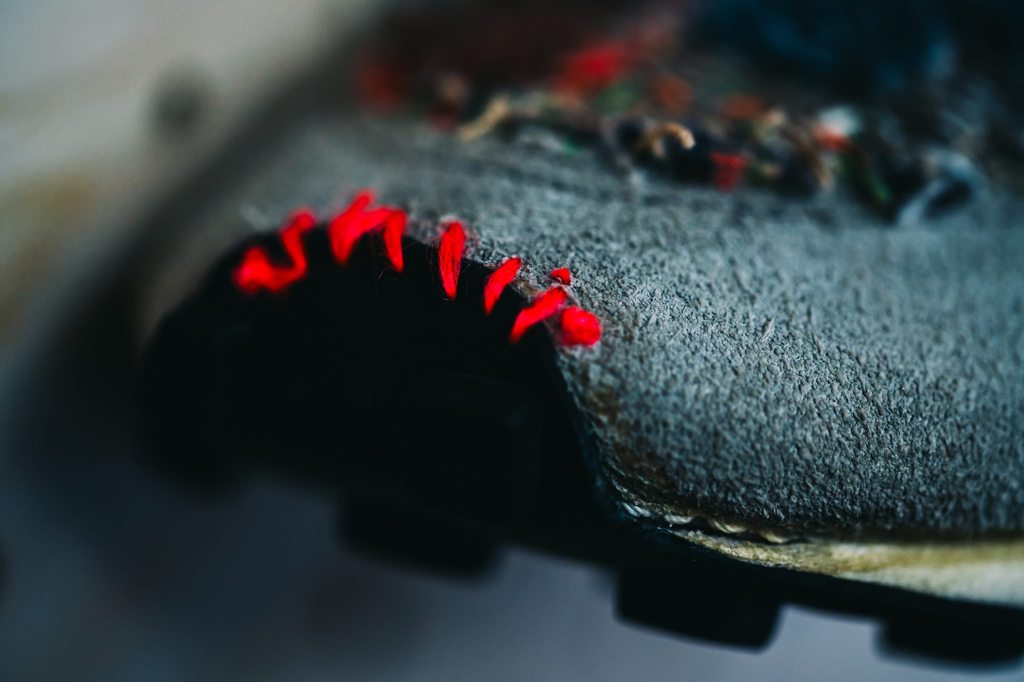 Red sashiko stitches on an indigo-dyed sneaker