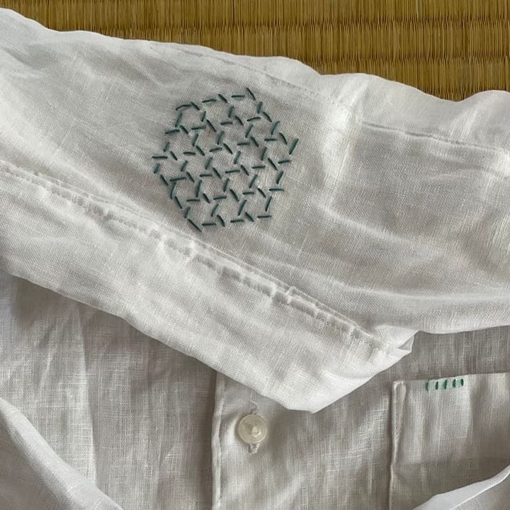 A blue semamori on a white linen shirt close-up