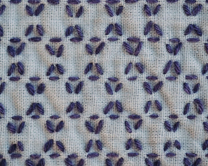 The kagome sashiko pattern in purple thread on blue cloth