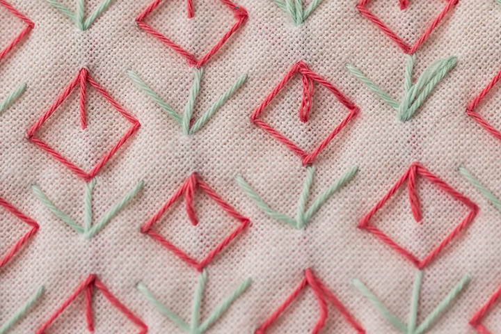 Sashiko pattern tulips in red and green on baby pink fabric